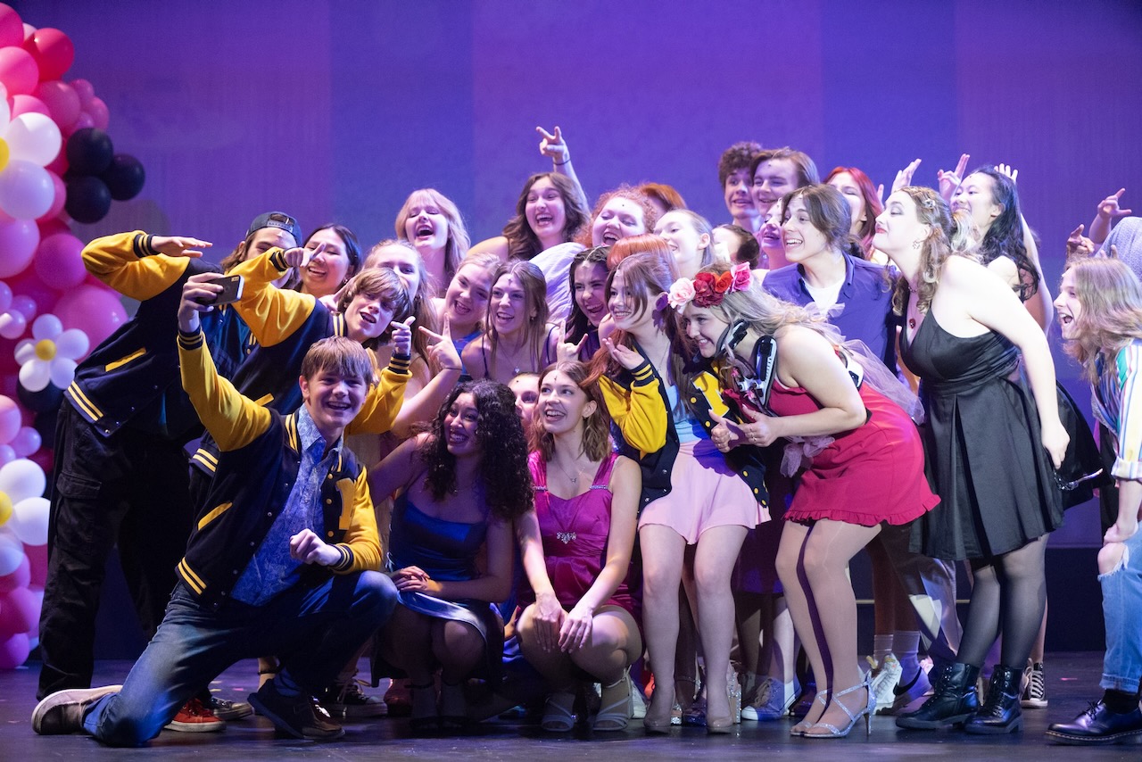 Full cast celebration with balloons on stage